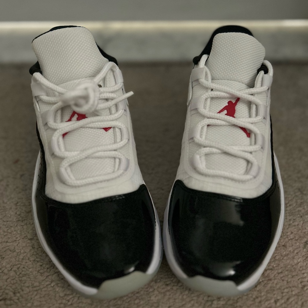 Nike Jordan Low 11’s CMFT Black and White Athletic Shoes with Red Details.